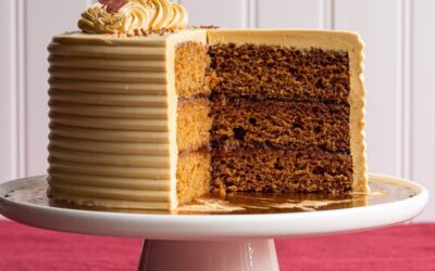 A Caramel Apple Cake with slices removed on a white cake stand